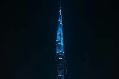 a tall building lit up in blue at night at Exclusive 2BR I Panoramic Views I Downtown Dubai in Dubai