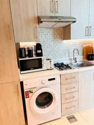 a kitchen with a washing machine and a microwave at Séjour raffiné et inoubliable in Dubai