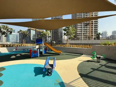 a playground with a slide and play equipment on a roof at Evasion Moderne a Business Bay vue sur le canal in Dubai