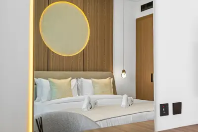 a hotel room with two beds and a mirror at Minimalist Studio in Binghatti Azure in Dubai