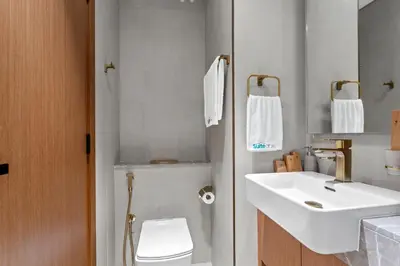 a bathroom with a white sink and a toilet at Minimalist Studio in Binghatti Azure in Dubai