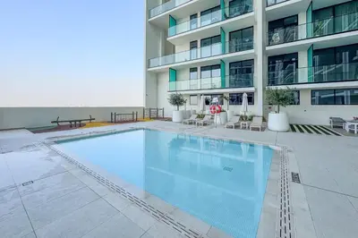 a large swimming pool in front of a building at Minimalist Studio in Binghatti Azure in Dubai