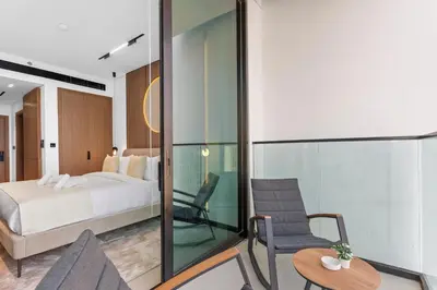 a bedroom with a bed and a chair and a table at Minimalist Studio in Binghatti Azure in Dubai
