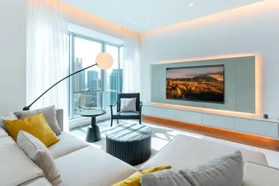 a living room with a couch and a tv on a wall at 2 BR Superb and Luxury Dubai Marina View in Dubai
