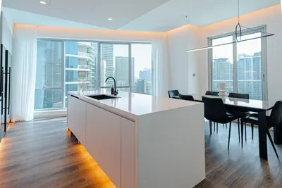 a kitchen with a white island and a table with chairs at 2 BR Superb and Luxury Dubai Marina View in Dubai