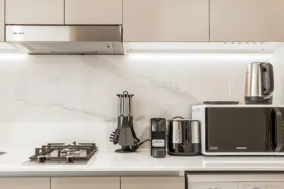 a kitchen counter with a stove and a microwave at Azizi Riviera 5, Meydan Close to Downtown - Onelink in Dubai