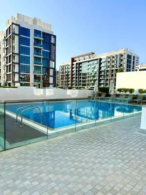 a swimming pool on the roof of a building with tall buildings at Azizi Riviera Studio High Floor Partial Burj View in Dubai