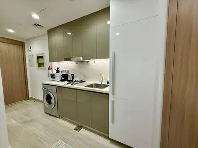 a kitchen with a sink and a refrigerator at Azizi Riviera Studio High Floor Partial Burj View in Dubai