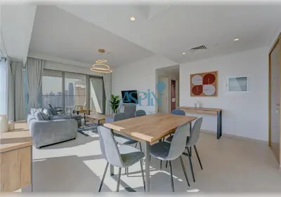 a living room with a wooden table and chairs at Downtown Views II - Burjkhalifa fireworks in Dubai