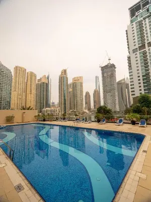 a large swimming pool in a city with tall buildings at Wonderful 2bd with full marina view HIGH FLOOR in Dubai