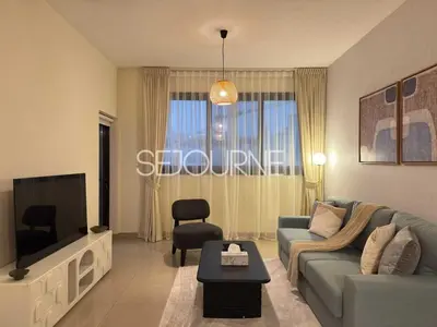 a living room with a couch and a tv at Cozy & Bright 1BR La Riviera Estate A in Dubai