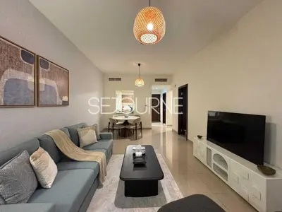 a living room with a blue couch and a flat screen tv at Cozy & Bright 1BR La Riviera Estate A in Dubai
