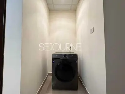 a washing machine in a hallway in a room at Cozy & Bright 1BR La Riviera Estate A in Dubai