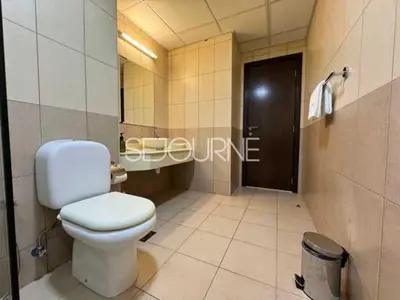 a bathroom with a white toilet and a mirror at Cozy & Bright 1BR La Riviera Estate A in Dubai