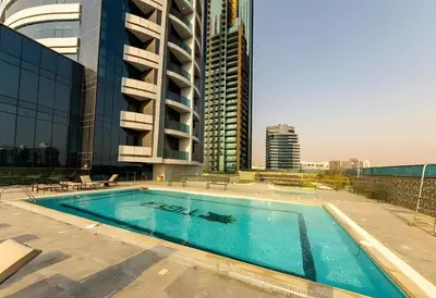 a swimming pool on the roof of a building at O2 Tower JVC, Cozy Home, Peaceful Studio Apartment in Dubai