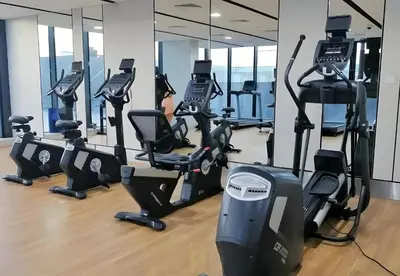 a gym with rows of treadmills and elliptical machines at O2 Tower JVC, Cozy Home, Peaceful Studio Apartment in Dubai