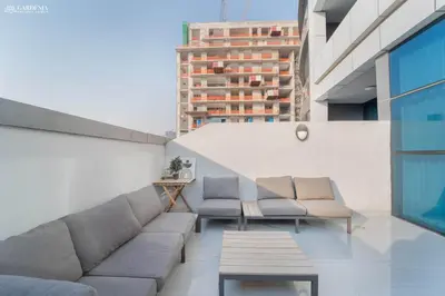 a balcony with couches and a table and a building at O2 Tower JVC, Cozy Home, Peaceful Studio Apartment in Dubai