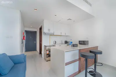 a kitchen with a counter and two bar stools at O2 Tower JVC, Cozy Home, Peaceful Studio Apartment in Dubai