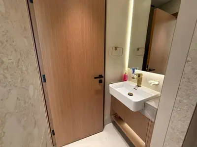 a bathroom with a sink and a wooden door at A place like home for relaxation in Dubai