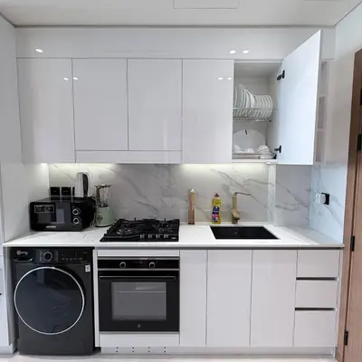 a white kitchen with a stove and a dishwasher at A place like home for relaxation in Dubai