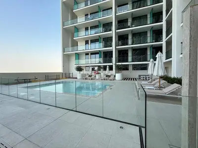 a large building with a swimming pool in front of it at A place like home for relaxation in Dubai