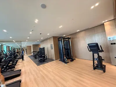 a gym with a row of treadmills and chairs at A place like home for relaxation in Dubai