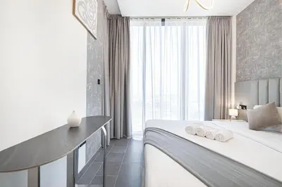 a hotel room with a bed and a large window at Luxurious Crest Tower Suites By Hostiva- Burj View in Dubai