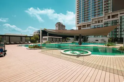 a large building with a swimming pool in front of a building at Luxurious Crest Tower Suites By Hostiva- Burj View in Dubai