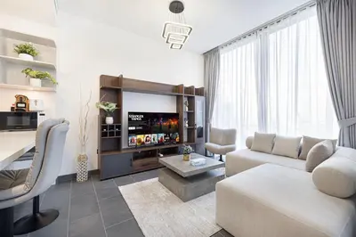 a living room with a couch and a tv at Luxurious Crest Tower Suites By Hostiva- Burj View in Dubai