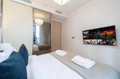 a bedroom with a white bed and a tv on the wall at 2BR Vida Dubai Mall Tower 2 Direct Mall Access in Dubai