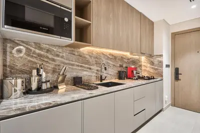 a kitchen with white cabinets and a counter top at Elegant Luxury Studio 12th Floor Sky high View in Dubai