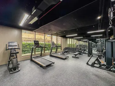 a gym with a row of treadmills and machines at Elegant Luxury Studio 12th Floor Sky high View in Dubai