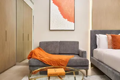 a living room with a couch and a glass table at Elegant Luxury Studio 12th Floor Sky high View in Dubai