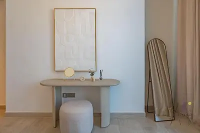 a table in a room with a mirror and a chair at Elegant & Spacious 2-BR Hideaway Riviera Bliss in Dubai