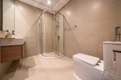 a bathroom with a shower and a toilet and a sink at Elegant & Spacious 2-BR Hideaway Riviera Bliss in Dubai