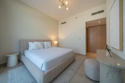 a bedroom with a large white bed and a desk at Elegant & Spacious 2-BR Hideaway Riviera Bliss in Dubai