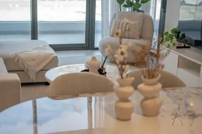 a living room with a coffee table and a chair at Elegant & Spacious 2-BR Hideaway Riviera Bliss in Dubai