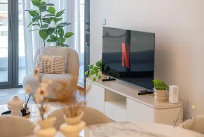 a living room with a chair and a television at Elegant & Spacious 2-BR Hideaway Riviera Bliss in Dubai
