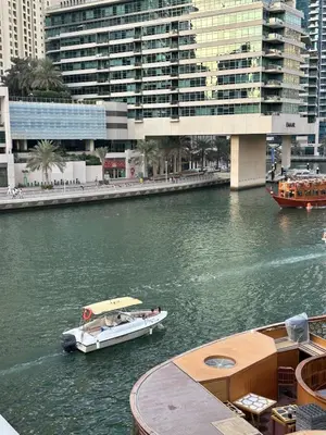 two boats in a river in a city with buildings at Fantastic 1 bed apt near Marina & Jumeira Beach in Dubai