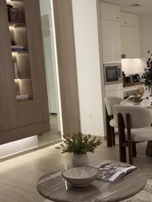 a living room with a table and a kitchen at Palace Residences, Lux 1BR Apartment, Lagoon View in Dubai