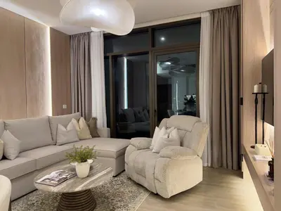 a living room with a couch and a chair at Palace Residences, Lux 1BR Apartment, Lagoon View in Dubai