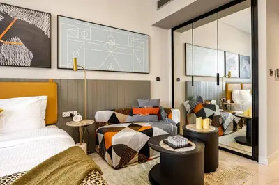 a bedroom with a bed and a table and a mirror at Minutes Walk To Dubai Mall Studio With All Comfort in Dubai