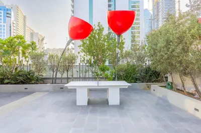 two red balloons sitting on top of a white bench at Minutes Walk To Dubai Mall Studio With All Comfort in Dubai