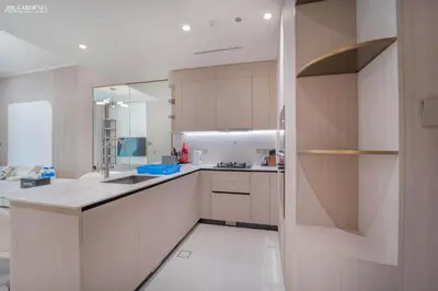 a kitchen with white cabinets and a sink and a mirror at Pearl House I JVC- 5 Star Facilities- Magnificent Apartment in Dubai
