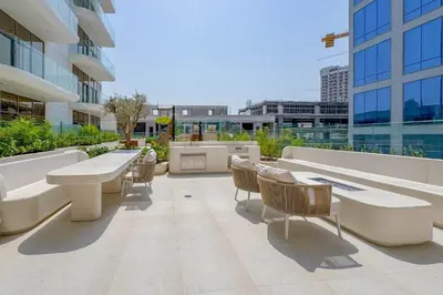 a patio with chairs and tables on a building at Pearl House I JVC- 5 Star Facilities- Magnificent Apartment in Dubai