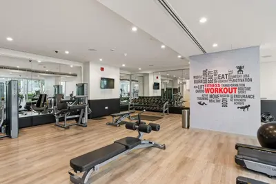 a gym with exercise equipment and a large wall at Burj Khalifa&City View 1BR, Near Dubai Water Canal, Vera Tower, Business Bay by Morada Holidays in Dubai