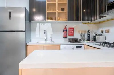 a kitchen with a white counter top and a refrigerator at Gemz by Danube with Private Pool - Onelink in Dubai
