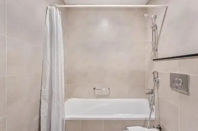 a bathroom with a shower and a bath tub at Sky-High Luxury Studio Overlooking Trump Golf Club-Carson A, DAMAC Hills, Dubai in Dubai