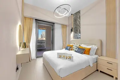 a bedroom with a large white bed and a window at Full Burj Khalifa 3BR in Act Towers in Dubai