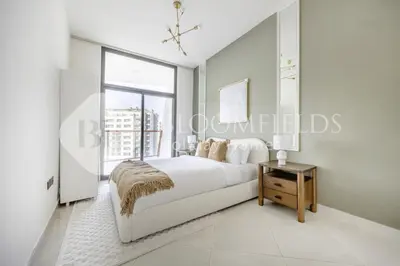 a white bedroom with a bed and a window at 202-Bloomfields Iconic 1br Binghatti Avenue in Dubai